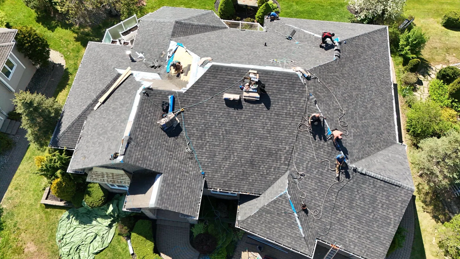Our crew working a Moncton roof from above, every man on a lifeline anchored across the deck