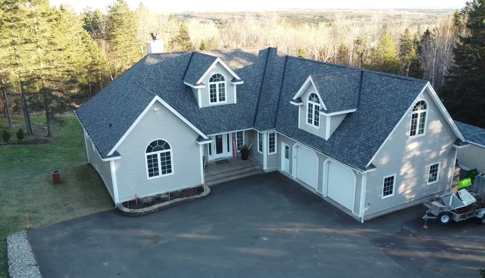 Finished dark architectural shingle roof on a large gabled country estate, photographed from our drone