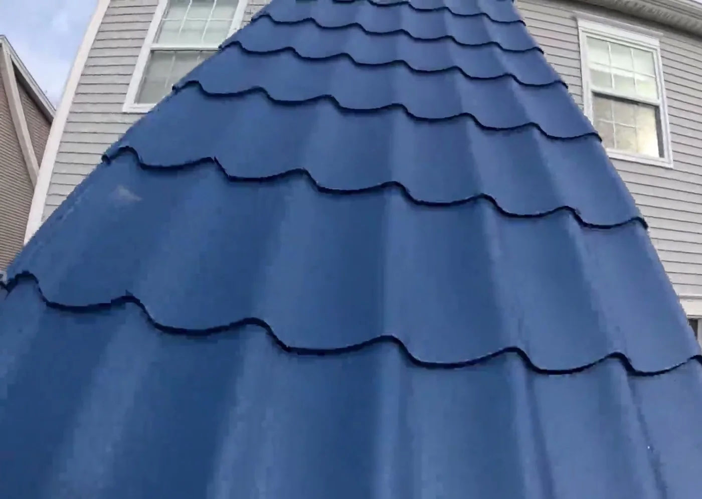 Finished blue European clay imitation steel tile roof, the barrel profile running down a gable