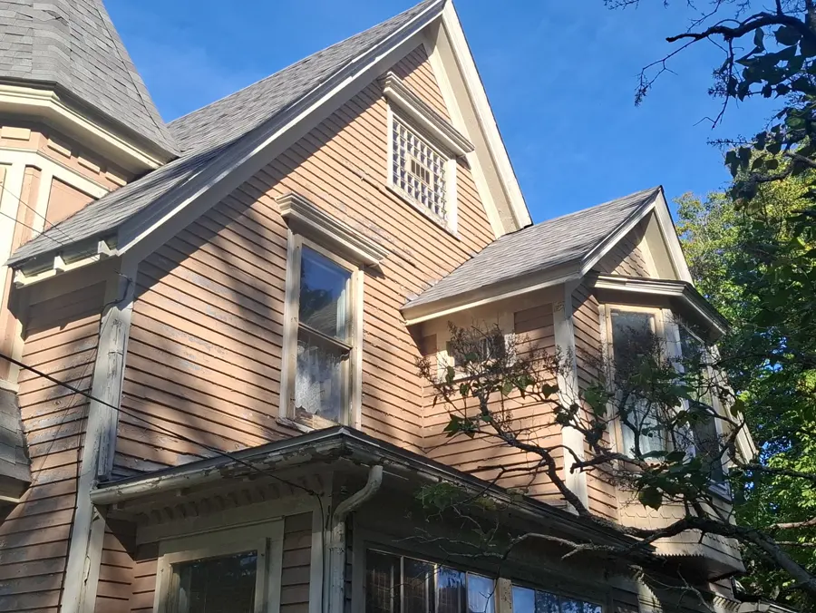 the Sackville Victorian front elevation before: aged tan Victorian with grey scalloped roof