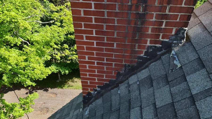 Red brick chimney on the old grey roof in Sackville